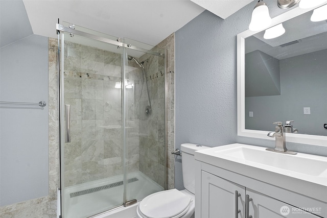 bathroom featuring visible vents, vanity, a shower stall, and toilet