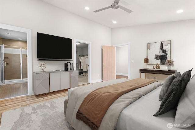bedroom featuring recessed lighting, a spacious closet, a ceiling fan, light wood-type flooring, and ensuite bath