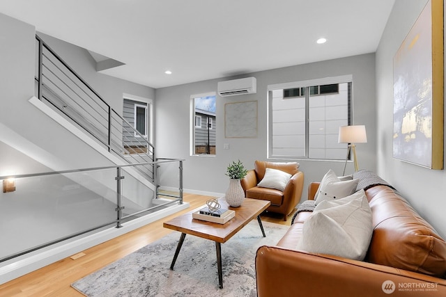 living area with wood finished floors, a wall mounted air conditioner, stairs, and recessed lighting