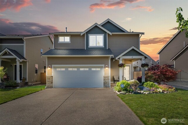 craftsman inspired home featuring concrete driveway, a front lawn, stone siding, and an attached garage