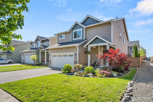 craftsman house with an attached garage, driveway, and stone siding