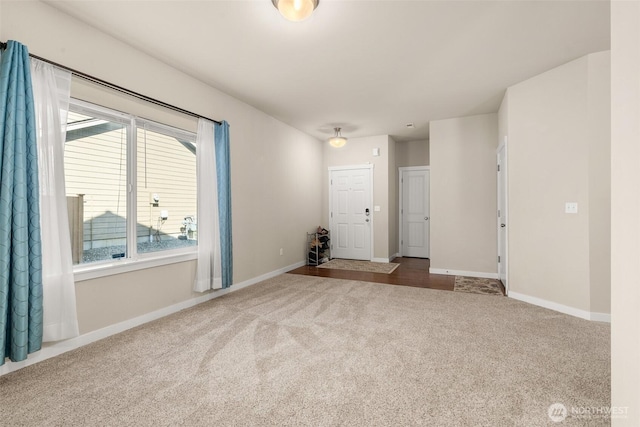 carpeted spare room featuring baseboards