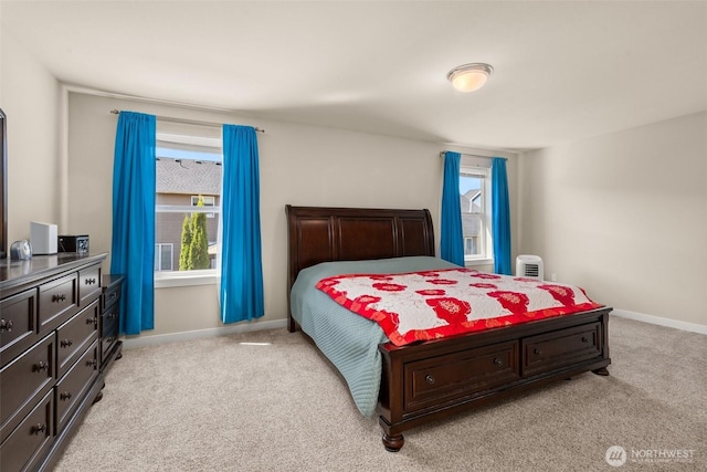 bedroom featuring light carpet, multiple windows, and baseboards