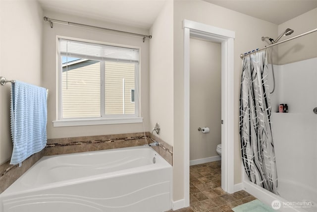 full bathroom with a bath, a shower stall, toilet, and baseboards