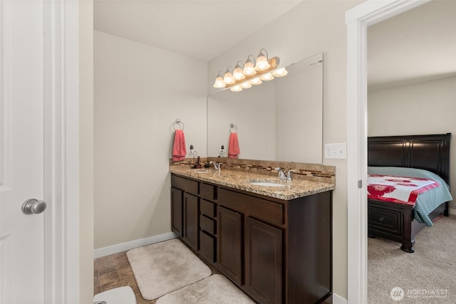 bathroom featuring connected bathroom, baseboards, and double vanity