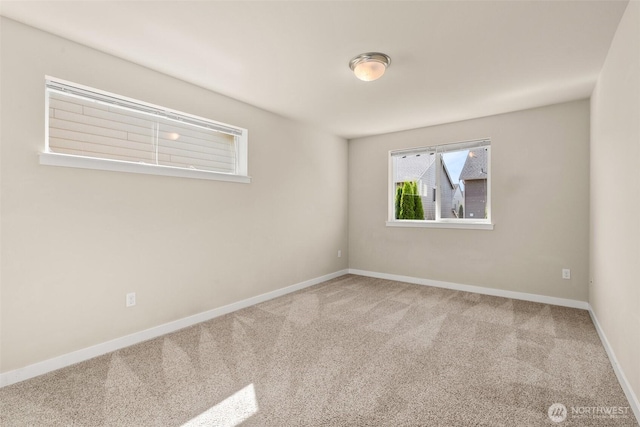 carpeted empty room featuring baseboards