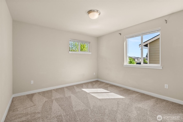 carpeted spare room with baseboards