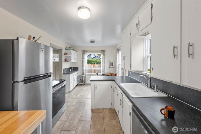 1921 N Stevens St, Tacoma, WA 98406 - kitchen featuring a sink, appliances with stainless steel finishes, white cabinets, and dark countertops