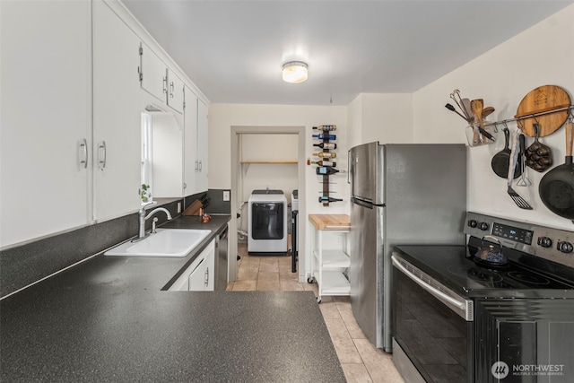 1921 N Stevens St, Tacoma, WA 98406 - kitchen featuring washer / dryer, dark countertops, white cabinetry, a sink, and stainless steel appliances