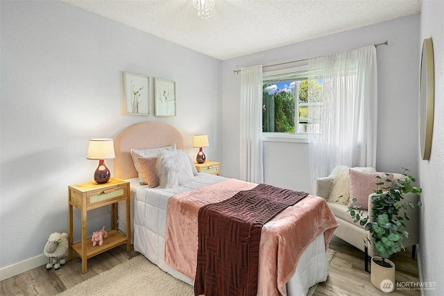 12910 6th Ave S, Burien, WA 98168 - bedroom with baseboards, wood finished floors, refrigerator, and a textured ceiling