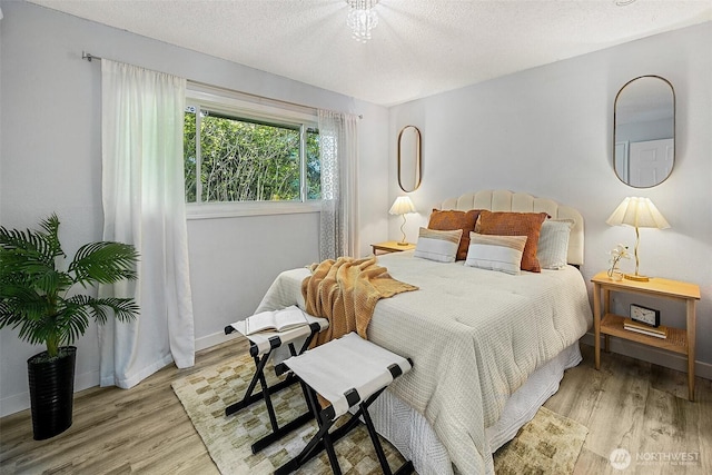 12910 6th Ave S, Burien, WA 98168 - bedroom featuring a textured ceiling, light wood-style flooring, and baseboards