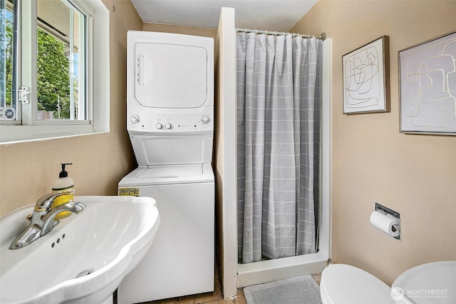 12910 6th Ave S, Burien, WA 98168 - bathroom with toilet, a shower stall, a sink, and stacked washer and clothes dryer