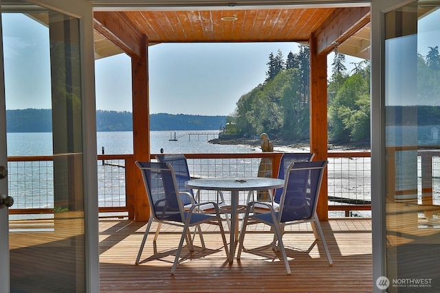 sunroom featuring a water view