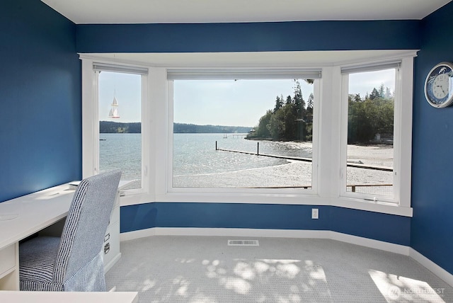 interior space with carpet floors, a water view, baseboards, and visible vents