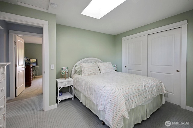 carpeted bedroom featuring a closet, baseboards, and a skylight