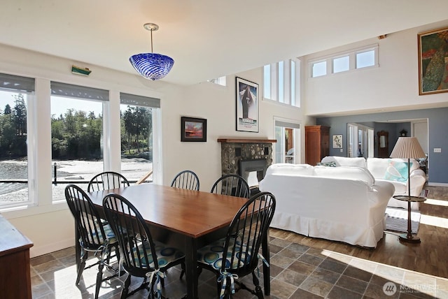 dining room featuring baseboards, stone finish flooring, and a fireplace