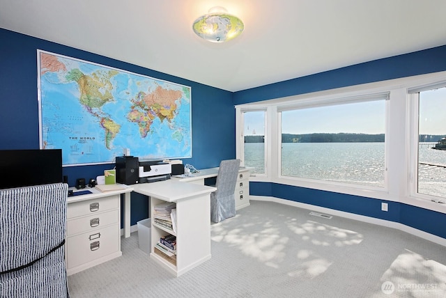office area with a healthy amount of sunlight, visible vents, and light colored carpet