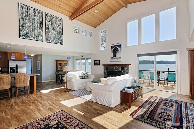 living area featuring high vaulted ceiling, beam ceiling, and light wood finished floors