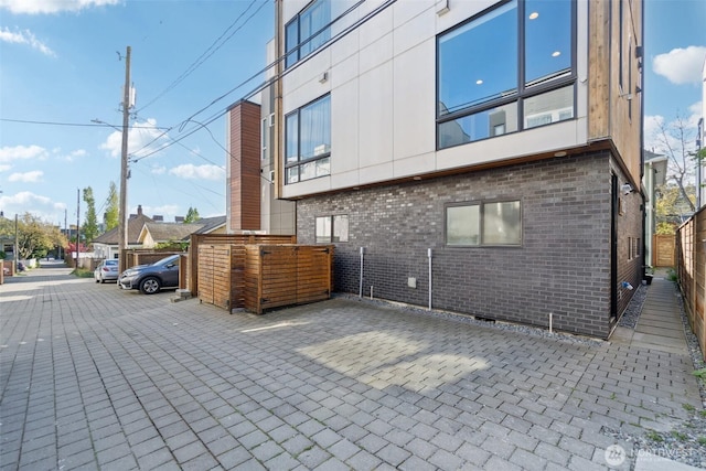 exterior space featuring fence and brick siding