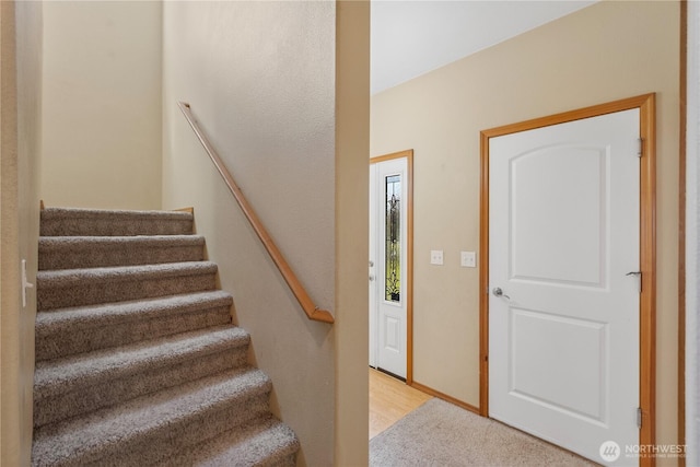carpeted foyer entrance featuring stairs