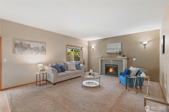living room with baseboards, a glass covered fireplace, and carpet floors