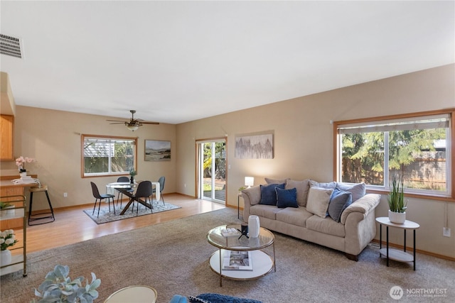 living area with ceiling fan, baseboards, wood finished floors, and visible vents