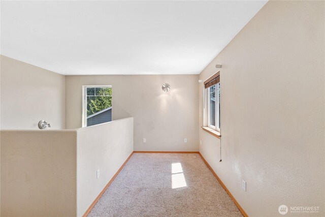 empty room featuring carpet and baseboards