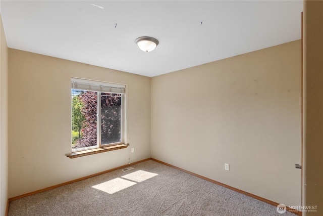 empty room with baseboards, carpet flooring, and visible vents