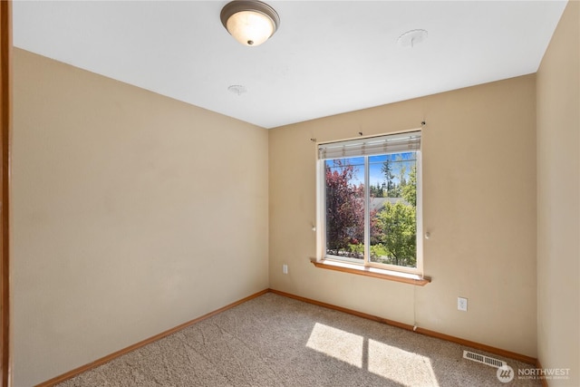 empty room with baseboards, carpet floors, and visible vents