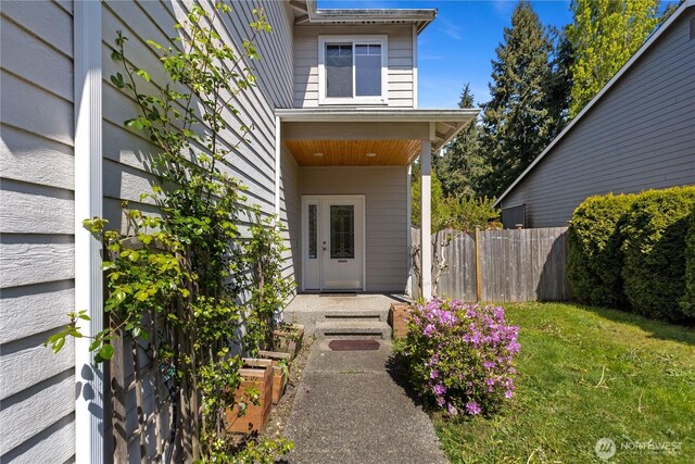 property entrance featuring fence and a yard