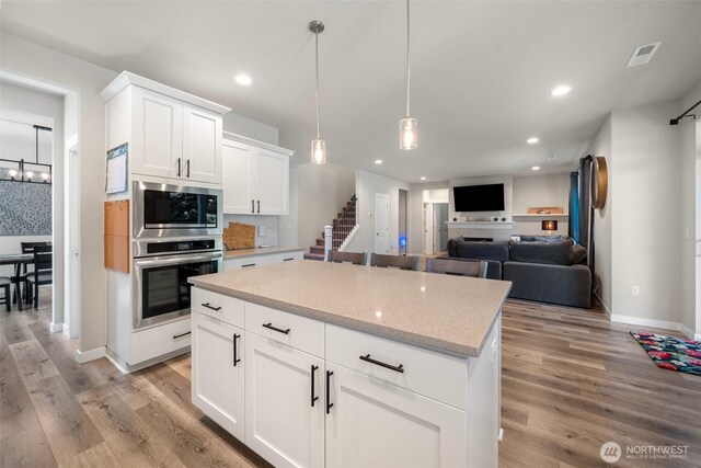 8852 N 5th St, Ridgefield, WA 98642 - kitchen featuring light wood finished floors, white cabinetry, baseboards, appliances with stainless steel finishes, and recessed lighting