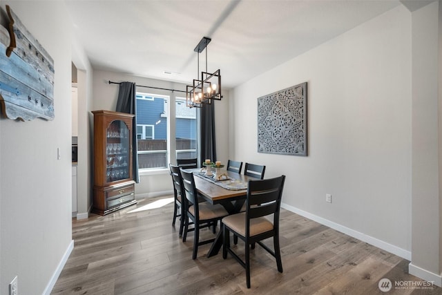 8852 N 5th St, Ridgefield, WA 98642 - dining room with an inviting chandelier, baseboards, visible vents, and wood finished floors