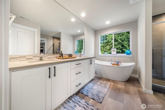 8852 N 5th St, Ridgefield, WA 98642 - full bathroom featuring double vanity, wood finished floors, a sink, visible vents, and a shower stall