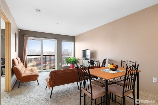 carpeted dining room featuring baseboards