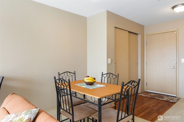 dining space with baseboards and wood finished floors