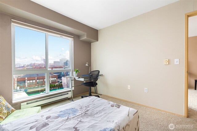 carpeted bedroom featuring baseboards and a baseboard radiator