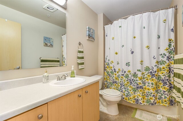 full bath with toilet, tile patterned floors, shower / tub combo with curtain, and vanity