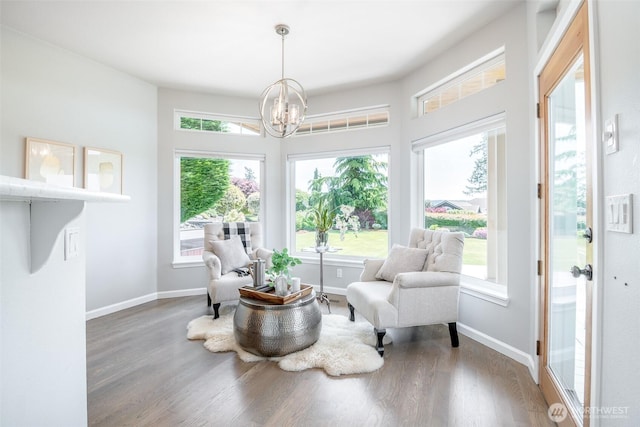 sitting room with a chandelier, wood finished floors, and baseboards