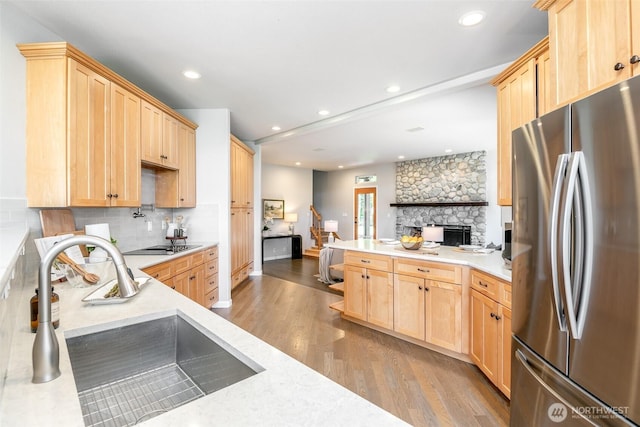 kitchen featuring freestanding refrigerator, light brown cabinets, a sink, wood finished floors, and recessed lighting