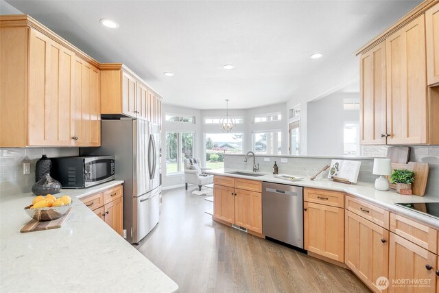 kitchen with appliances with stainless steel finishes, light brown cabinetry, a sink, light wood-style flooring, and recessed lighting