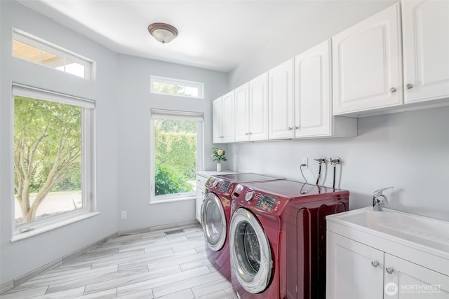 laundry area featuring cabinet space, washer and dryer, and light wood finished floors