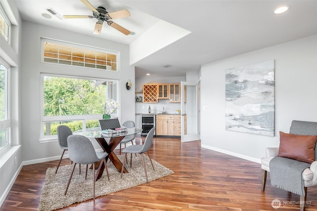 dining area with wet bar, wood finished floors, beverage cooler, recessed lighting, and baseboards