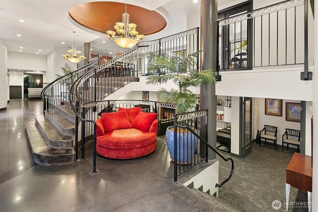 323 Queen Anne Ave N Unit 508, Seattle, WA 98109 - staircase with a high ceiling, an inviting chandelier, finished concrete flooring, recessed lighting, and baseboards