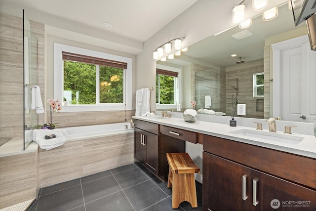 full bath featuring double vanity, tiled shower, a bath, tile patterned floors, and a sink