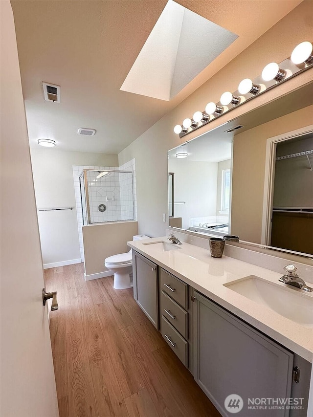 full bath with a sink, toilet, double vanity, visible vents, and a shower