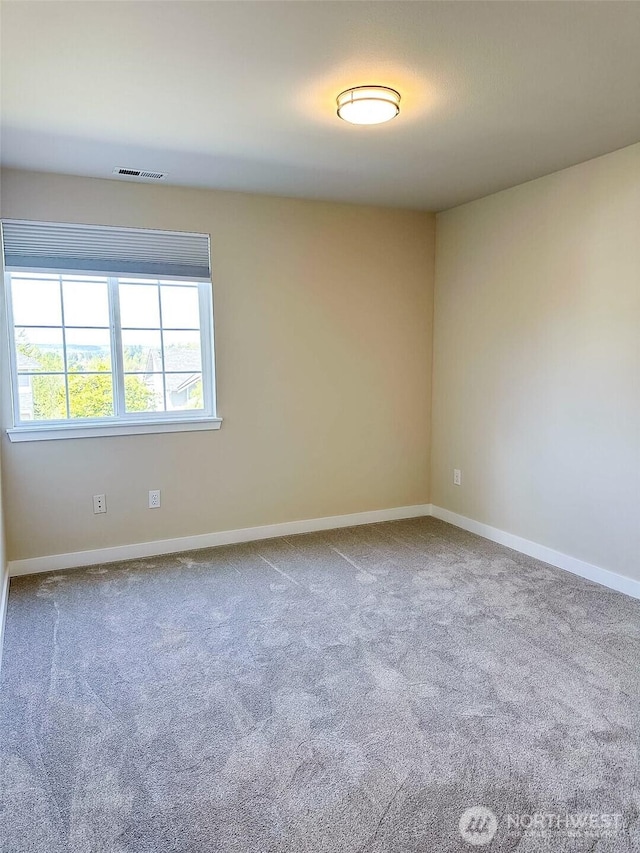 unfurnished room featuring baseboards, visible vents, and carpet flooring