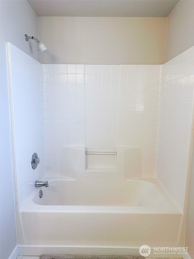 bathroom featuring baseboards, tile patterned floors, and bathtub / shower combination