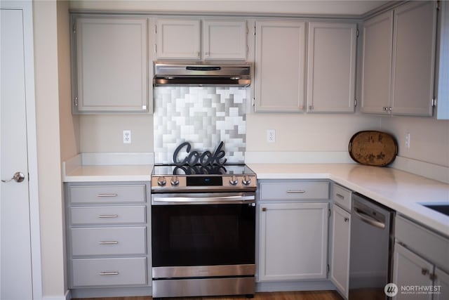 kitchen with gray cabinets, ventilation hood, and stainless steel appliances