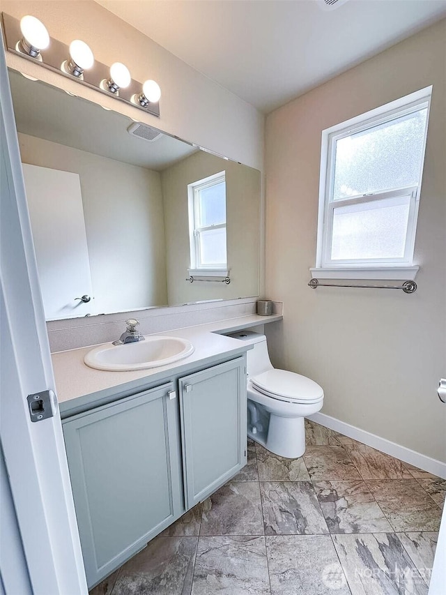 bathroom with visible vents, baseboards, toilet, vanity, and marble finish floor