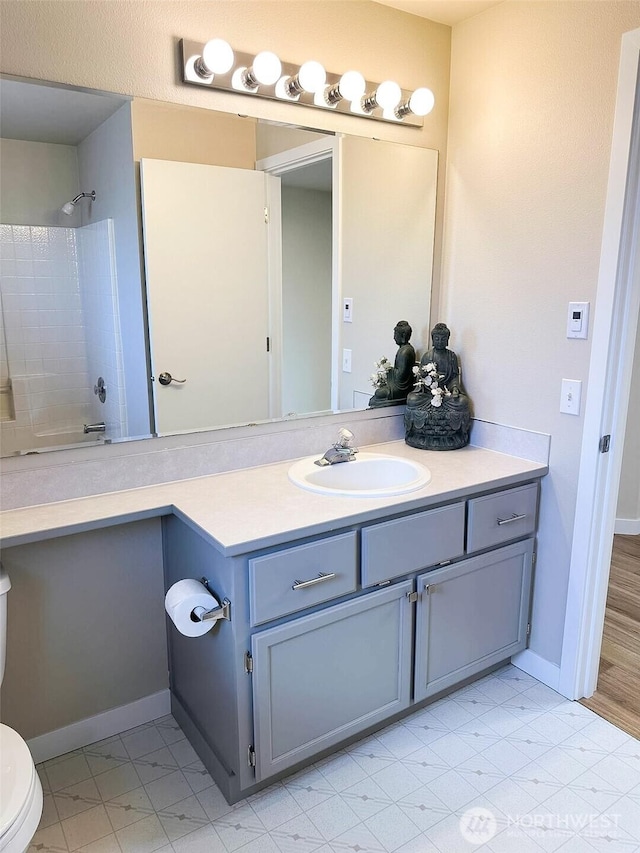 full bath with baseboards, toilet, and vanity
